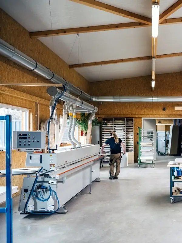 Vue d'ensemble d'un atelier industriel partagé avec établis et machines