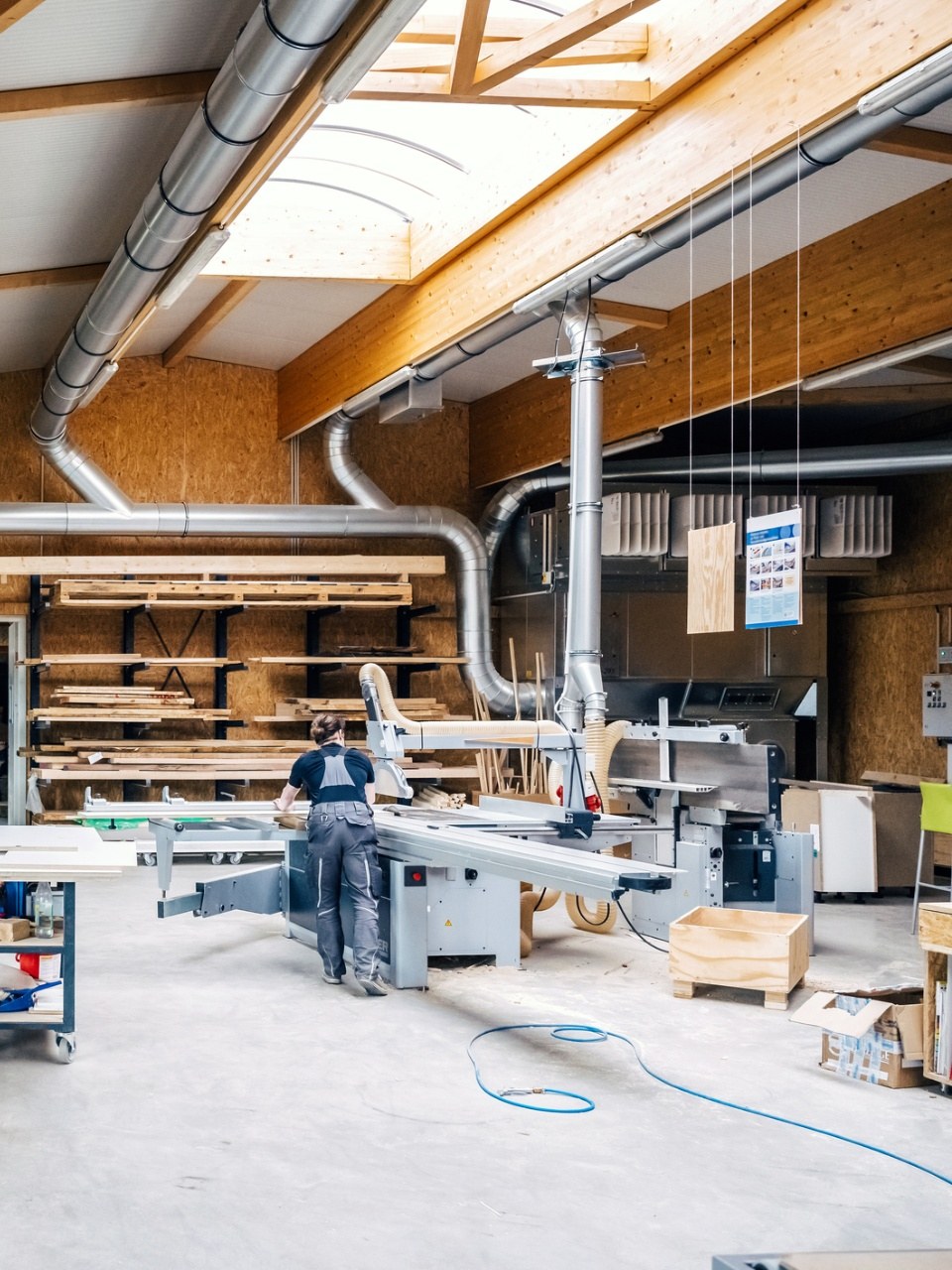 Vue d'ensemble d'un atelier industriel partagé avec établis et machines